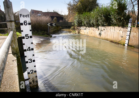 Un guado una strada in acqua bassa condizioni che mostra il bianco e nero scale di misura a lato. Foto Stock