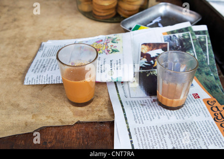 Bicchieri di tè chai e giornale sul tavolo Foto Stock