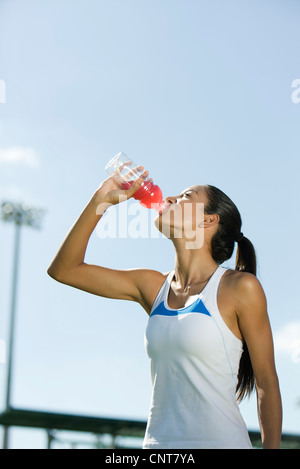 Giovane atleta femminile bere drink sport, ritratto Foto Stock