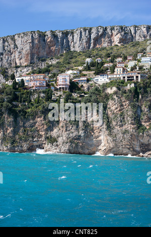 Case scogliera nel quartiere di les Pissarelles di Cap d'Ail che si affaccia sul mare azzurro del mediterraneo. Costa Azzurra, Francia. Foto Stock