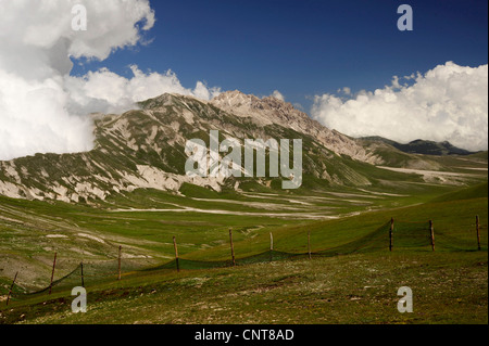 Alpeggio recintata su un vasto prato secco pianure nella parte anteriore di una catena montuosa, Italia, Nationalpark Abruzzo Foto Stock