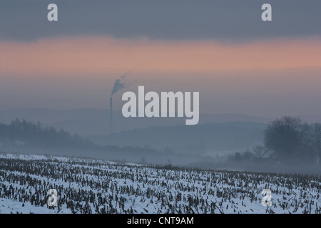 Alba sul paesaggio snovy e la nebbia di mattina, con un camino di fumo nella nebbia, in Germania, in Sassonia, Vogtlaendische Schweiz Foto Stock