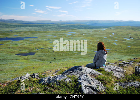 Donna contro il verde altopiano con numerosi piccoli laghi. Foto Stock