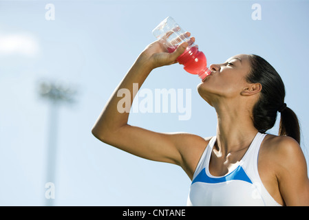 Giovane atleta femminile bere drink sport, ritratto Foto Stock