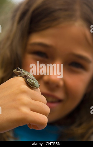 Ragazza che mostra una rana seduta sul retro della sua mano, Francia Foto Stock