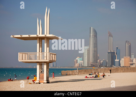La spiaggia pubblica con bagnino edificio e lo skyline di Abu Dhabi, Emirati Arabi Uniti, Asia Foto Stock
