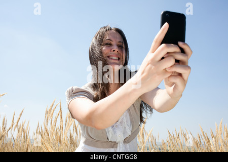 Donna di scattare le foto con il telefono cellulare Foto Stock