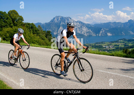 Uomo e donna con bici da corsa su un tour nelle montagne alpine, con il lago Traunsee dietro, Austria, Austria superiore, Gmunden Foto Stock