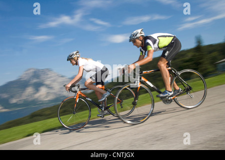 Uomo e donna con bici da corsa su un tour nelle montagne alpine, con il lago Traunsee dietro, Austria, Austria superiore, Gmunden Foto Stock