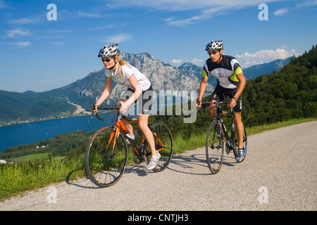 Uomo e donna con bici da corsa su un tour nelle montagne alpine, con il lago Traunsee dietro, Austria, Austria superiore, Gmunden Foto Stock