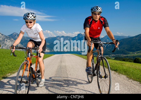 Uomo e donna con bici da corsa su un tour nelle montagne alpine, con il lago Traunsee dietro, Austria, Austria superiore, Gmunden Foto Stock