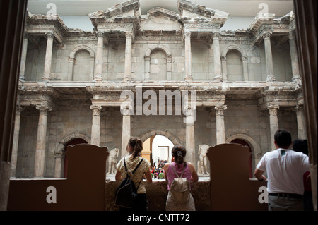 I visitatori del Pergamon Museum situato sull'Isola dei Musei di Berlino Mitte guardando la porta del mercato di Mileto Foto Stock