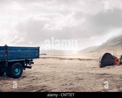 Carrello blu e scavatrice nel campo secco Foto Stock