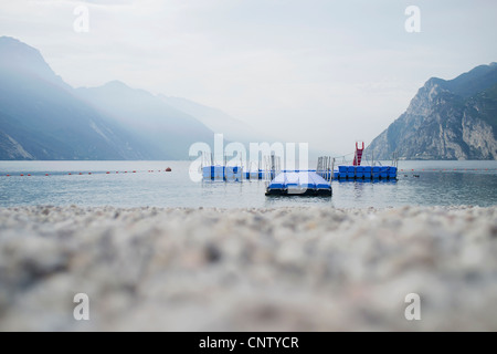 Il molo galleggiante off spiaggia rocciosa Foto Stock