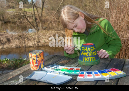 Bambino preparare un plowerpot come posto per dormire vor earwigs, Germania Foto Stock