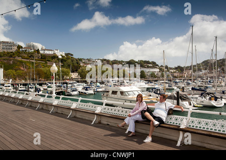 Regno Unito, Inghilterra, Devon, Torquay, Princess Pier, giovane sat nella luce del sole a barche ormeggiate nella Marina Foto Stock