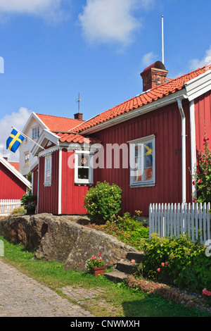 Rosso piccolo cottage sulla strada in un villaggio in Svezia Foto Stock