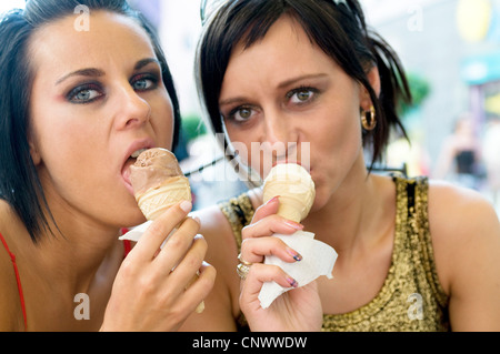 Blackhaired due giovani donne a mangiare il gelato Foto Stock