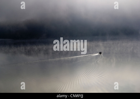 Due fisher in una barca da pesca nel lago nella nebbia mattutina, in Germania, in Sassonia, Bleiloch-Talsperre Foto Stock