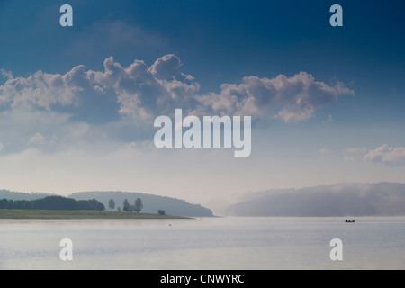 Il lago con la barca nella nebbia di mattina la cancellazione di distanza, in Germania, in Sassonia, Vogtland, Talsperre Poehl Foto Stock