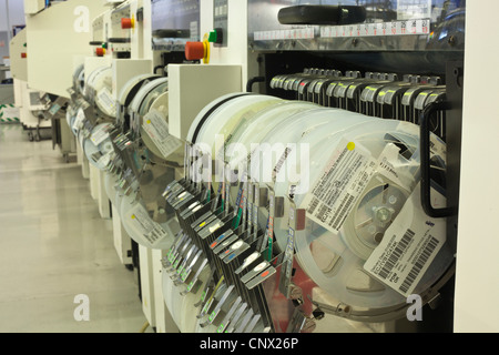 SMT componenti SMD caricato sugli alimentatori e posizionamento dei carrelli della macchina pronta per la produzione. Foto Stock