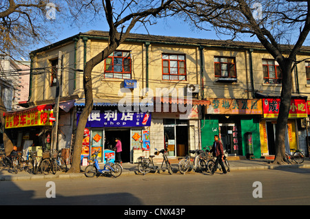 Negozi ed appartamenti in una parte della rete di vecchie strade ed edifici (hutong) ancora esistenti a Pechino in Cina. Foto Stock