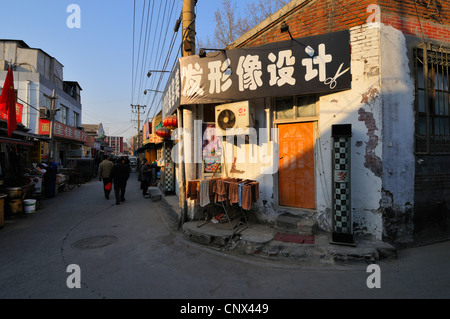 Negozi ed appartamenti in una parte della rete di vecchie strade ed edifici (hutong) ancora esistenti a Pechino in Cina. Foto Stock