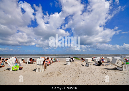 Spiaggia di sabbia con i bagnanti intorno a sdraio in spiaggia, Germania, Bassa Sassonia, Frisia orientale, Wangerooge Foto Stock