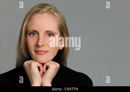 Ritratto di giovane e bella donna con le mani sul mento Foto Stock