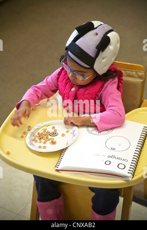 Utilizzando Cheerios, un non vedente bambino impara la lettera 'O' toccando presso i bambini ciechi Learning Center di Santa Ana. Foto Stock