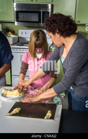 Un insegnante aiuta un handicappato non vedenti fanno preteen rotoli da toccare dalla pasta preparata in una classe di cucina, Santa Ana CA. Foto Stock