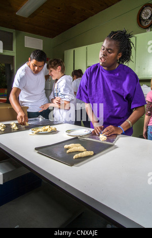 Afro-americano di cieco preteen girl produce rotoli da toccare in una lezione di cucina presso i bambini ciechi del Centro di apprendimento, Santa Ana. Foto Stock