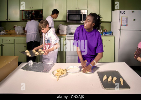 Afro-americano di cieco preteen girl produce rotoli da toccare in una lezione di cucina presso i bambini ciechi del Centro di apprendimento, Santa Ana. Foto Stock