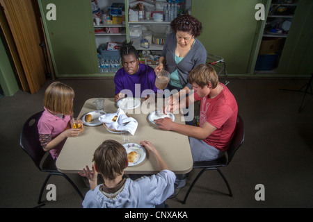 Un insegnante si unisce a lei cieca e studenti handicappati cibo di campionamento sono realizzati in una lezione di cucina presso la Tenda Centro per l'infanzia. Foto Stock