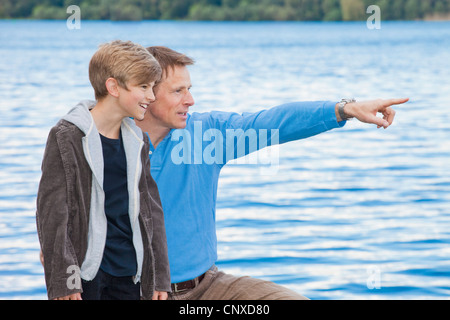 Un padre di puntamento fuori qualcosa di suo figlio, all'aperto Foto Stock