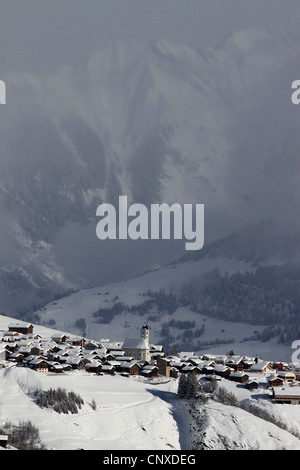 Villaggio innevato con la gamma della montagna e di valle in background Foto Stock