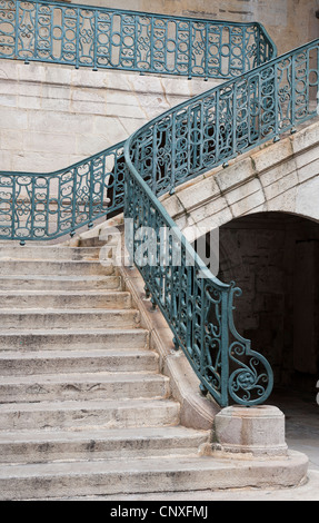 Scale di pietra caso con ringhiere in ferro battuto e parapetti Foto Stock