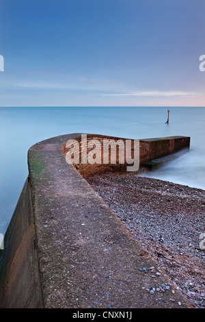 Stone jetty di Sidmouth sulla spiaggia al tramonto, Sidmouth, Devon, Inghilterra. Inverno (gennaio 2012). Foto Stock