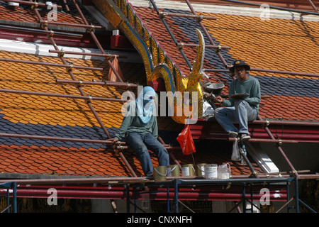 Lavoratori riparare il tetto di uno del tempio di Wat Phra Kaew a Bangkok, in Thailandia. Foto Stock