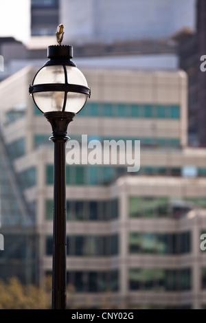 Una lampada posta sul Tamigi contro uno sfondo di edifici per uffici Foto Stock