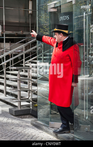 Città di Londra Lloyds portiere portiere concierge nella tradizionale livrea rosso tonaca cappotto & black top hat rifilato con treccia in oro Foto Stock