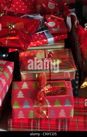 Una messa di Natale regali avvolti in rosso e oro la carta con i nastri REGNO UNITO Foto Stock