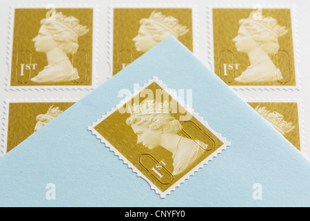 Regno Unito, Gran Bretagna. Royal Mail prima classe francobolli e una busta con un timbro bloccato su On Foto Stock