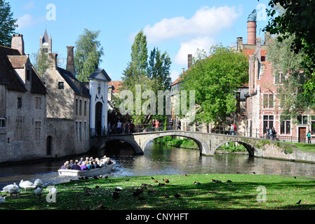 Belgio - Bruges - canal scena - Wijngaard plein - canal tour in barca - cigni - bridge - vecchi edifici - Luce solare - cielo blu Foto Stock