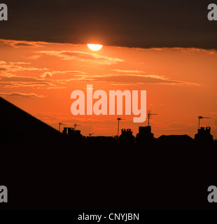 Tramonto su casa suburbana tetti nel sud di Londra con Orange Sky glow Foto Stock