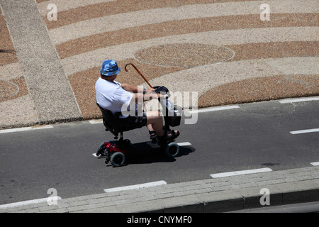 Un uomo adulto guida uno scooter elettrico 3 ruote handicappato a Tel Aviv Seacoast Promenade Israele Foto Stock