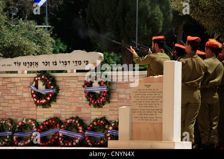 I soldati israeliani dell'unità di comando del fronte domestico che spara la pistola salutano sopra le tombe dei soldati caduti in Yom Hazikaron Memorial Day per i soldati caduti in Kiryat Shaul sepoltura ebraica nel nord di Tel Aviv Israele Foto Stock