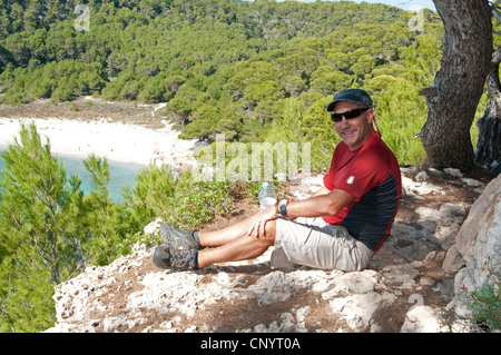 Un rambler sopra Trebaluger sulla spiaggia di La Cami de Cavalls passeggiata costiera menorca Spagna Foto Stock