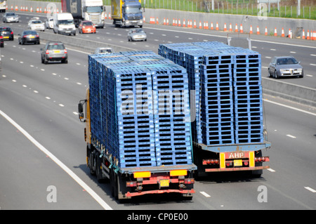 Immagine di trasporto vista posteriore da sopra due autocarri autocarri rimorchio articolato hgv autocarri caricati con pallet in legno blu sorpasso su autostrada UK Foto Stock