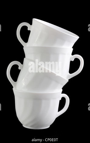 Pila di tazze bianco isolato a sfondo scuro Foto Stock